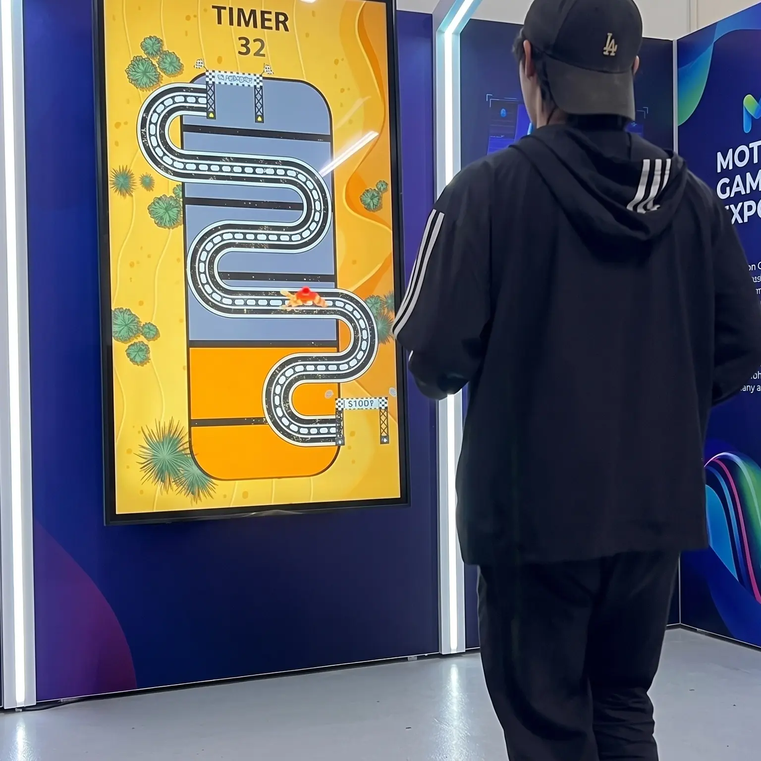 Guests playing the Interactive Camel Race in Dubai, running on custom foot pads to make digital camels sprint across a massive LED screen at a live event.